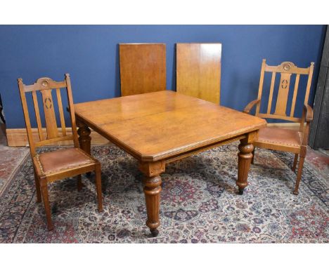 A circa 1900 light oak wind out extending dining table with two additional leaves, on turned columns, with eight light oak ch