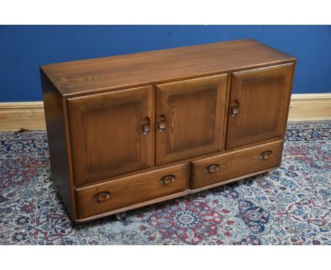 ERCOL; a medium elm 'Golden Dawn' sideboard, with three panelled doors above two drawers, width 130cm, depth 43cm, height 76c