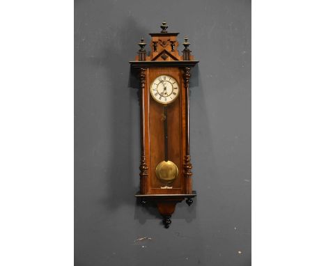 A late 19th century beech cased Vienna style wall clock, with three finial pediment above the enamel dial set with Roman nume