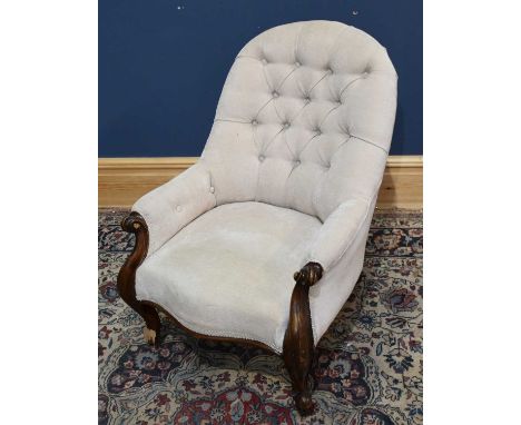 A Victorian nursing chair upholstered in a button back material.