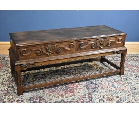 A reproduction carved oak two drawer hall table, height 60cm, width 137cm, depth 52cm.