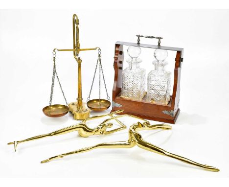 A reproduction tantalus housing two cut glass bottles, balance scales with more than two brass dancing figures.