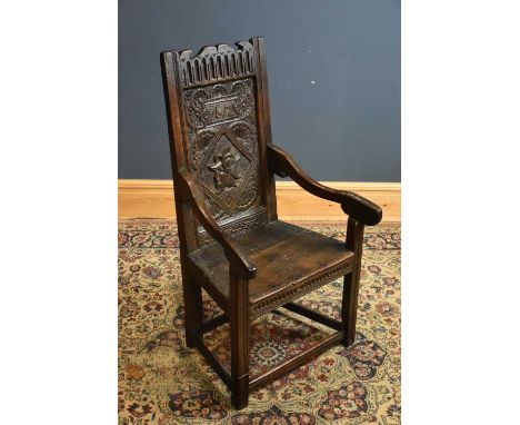 A 17th century and later carved oak wainscot type chair, with carved back inscribed date 1612 with side profile of a soldier 