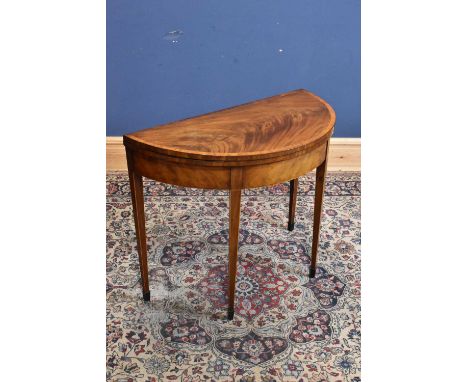 A Georgian inlaid mahogany demi-lune fold-over card table with baize material, on spade feet, width 94cm, height 74cm.