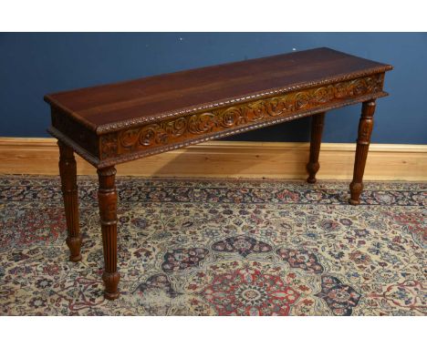 A reproduction cherrywood console table with carved decoration on turned column supports, length 158cm, depth 44cm, height 76