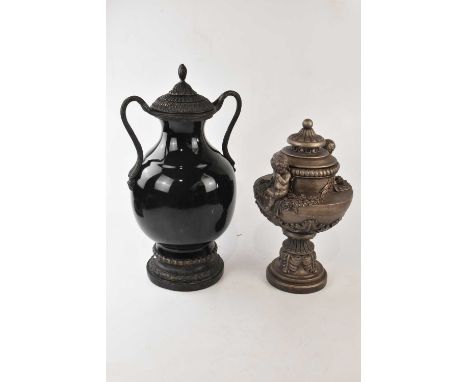 A modern black ceramic cast metal twin handled lidded urn, height 54cm and a smaller example modelled with seated cherubs (2)