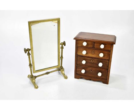 A mahogany miniature chest of two short over three long drawers, with ceramic knobs, width 21cm, height 26cm, and a brass swi