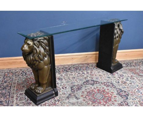 A decorative console table with plate glass top on a pair of gilt composite lions, height 90cm, width 183cm.