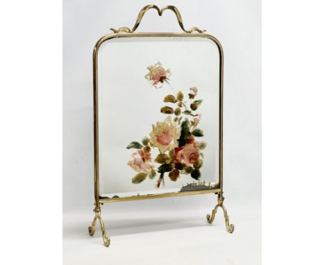 An Edwardian brass framed firescreen with painted mirror. 43x19x69cm 