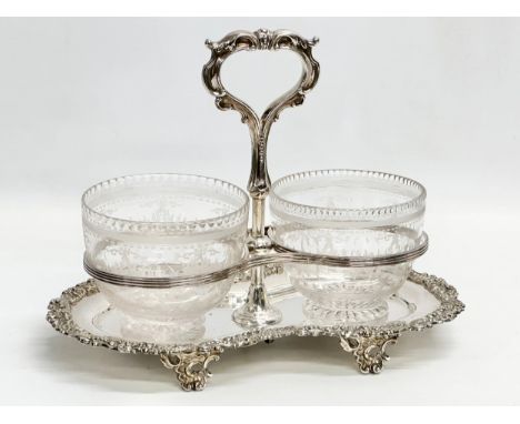 A Victorian silver plated sugar and cream stand/tea caddy, with etched glass bowls. Bowls measure 10x8cm. Stand 26x15x20cm 