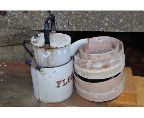 An enamel flour bin, an enamel watering can and four flour sieves.