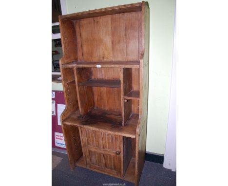 A Pine shelf unit with various adjustable shelves and lower cupboard, 32" wide x 68" high x 16 1/2" deep.