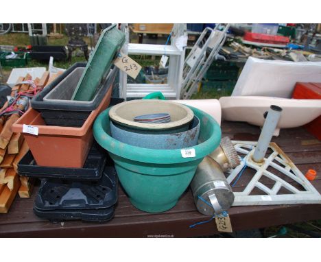 Some plastic pots, plant trays, stainless steel flue pipe and a parasol stand.