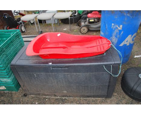 A plastic storage box, 46" wide x 19" depth x 2' high, and a red sledge.