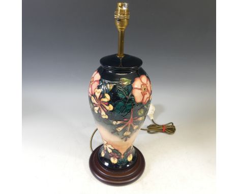 A Moorcroft 'Oberon Honeysuckle' pattern Table Lamp, with tubelined decoration on a blue and salmon ground, on wooden base, H