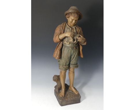 A Goldscheider Wien painted terracotta Figure of a Young Boy, modelled holding a matchbox, stamped to reverse 'Goldscheider W