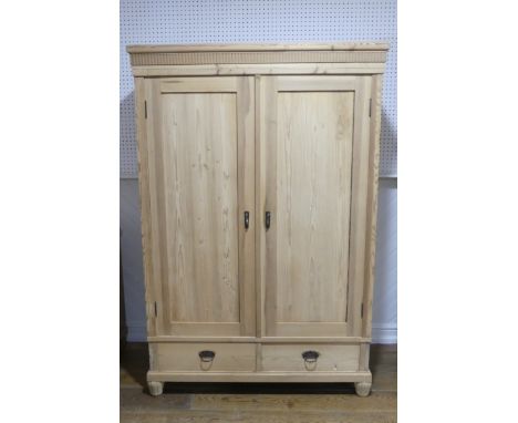An antique pine double Wardrobe, with panel doors and two drawers, on fluted feet, W:125 x H:186 x D:59. 