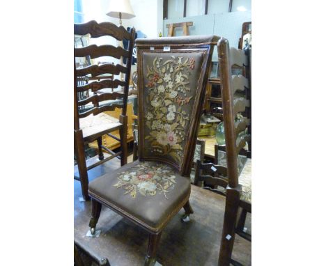 An early 20th Century oak framed prayer chair, upholstered in a tapestry floral decoration.