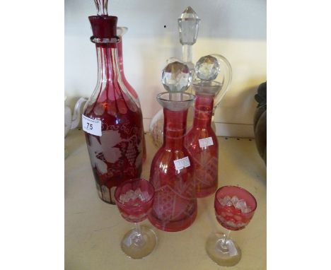 A collection of four ruby glass decanters together with two further similar sherry glasses and a further clear cut glass deca