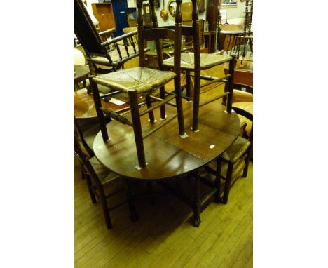 An 19th Century oval oak drop leaf table raised upon carved ball and claw feet, along with four matching but non conforming o