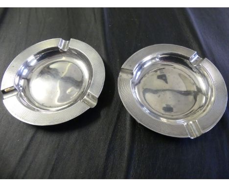 A pair of Art Deco hallmarked silver ashtrays of circular form with engine turned  rim.