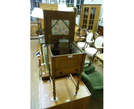 A 20th Century oak sewing cabinet on barleytwist legs together with a further small smokers pipe stand and tobacco container 
