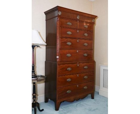 A George III/IV mahogany inlaid chest-on-chest circa 1820, the moulded cornice over a frieze applied with three embossed bras