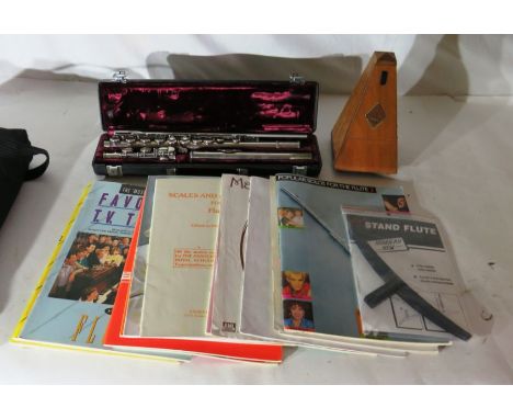 A flute by Buffet, Crampon Paris, cased, a metronome and various associated training manuals