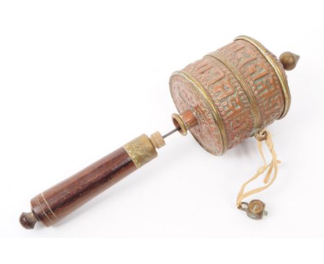 A 19th century Tibetan prayer wheel, featuring a wooden handle and a relief copper wheel with a finial atop. Bronze pendant a