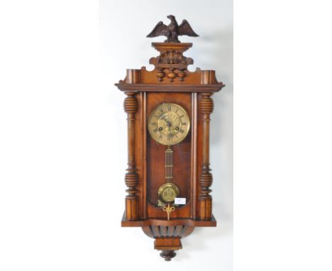 19th century Victorian mahogany wall clock with a glazed case and carved eagle mount atop. The case contains a brass clock me