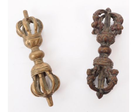 Two 19th century Tibetan Buddhist Dorjes ritual objects, featuring one in bronze with detailed carvings and one in brass. The