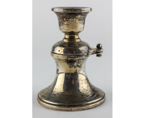 A George V novelty silver inkwell cum candlestick, of waisted form, the candle holder hinged to reveal the inkwell, hallmarke