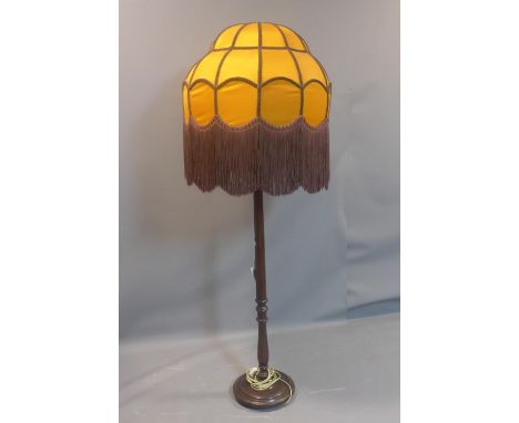 A vintage standard lamp with large orange shade with tassels, on turned support, H.175cm 
