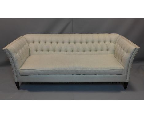 A sofa in pale grey buttoned upholstery on square tapering supports. H.86 W.223 D.90cm 