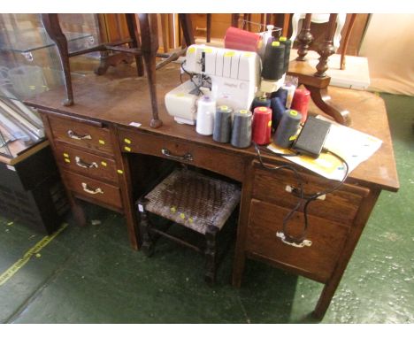 A VINTAGE OAK SIX-DRAWER DESK WITH STATIONERY SLIDES AND PAINTED METAL HANDLES