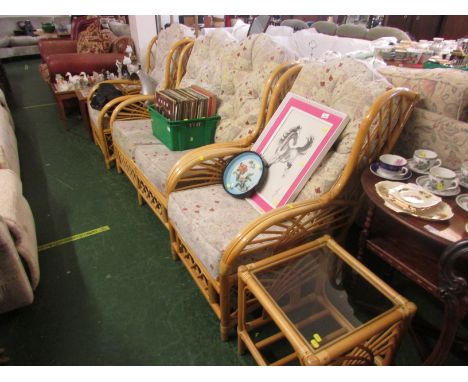 Cane framed conservatory set comprising two seater sofa, pair of armchairs with foliate upholstered cushions, and a glass top