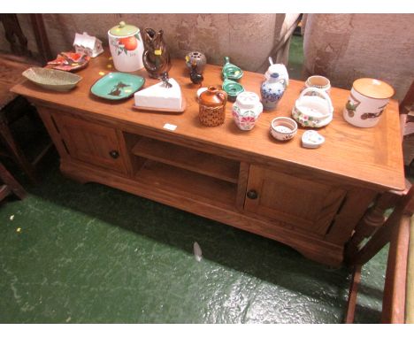 MODERN LIGHT OAK LOUNGE UNIT WITH SINGLE CUPBOARD DOORS EITHER SIDE AND CENTRAL SHELF.