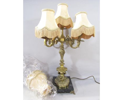 A five branch candelabra table lamp in the Georgian style with elaborate gold arms supported by kneeling putti, together with