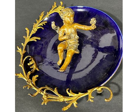 19th century continental blue ceramic wall plate, the blue ceramic dish surmounted by trailing floral band and cherub 
