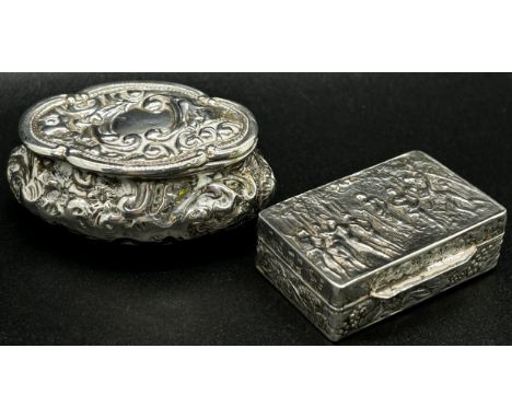 A silver snuff box with classical muses to the lid, together with an oval shaped snuff box with scrolled engraving (2) 