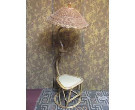 A vintage bound cane work low table and combined lamp with raised shaped neck supporting a tilted wicker shade with raised fi