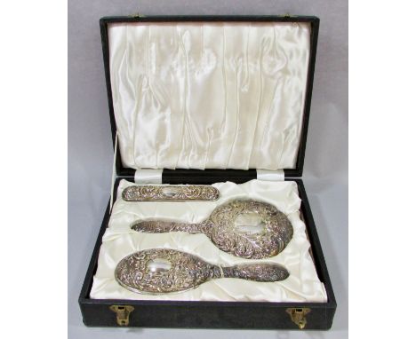 An early 20th century silk lined box with a silver hair brush set, a hand mirror, hair and clothes brushes and a comb, all wi