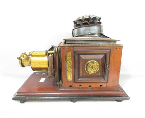 A Victorian Triumph Magic Lantern slide projector on a mahogany plinth. 