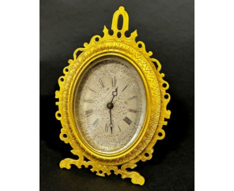 Engraved gilt easel clock in the manner of Thomas Cole, the silvered dial finely engraved with foliated detail 