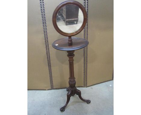 A Victorian walnut shaving stand with adjustable circular framed mirror, raised on a fluted colum and scrolled tripod, 134cm 