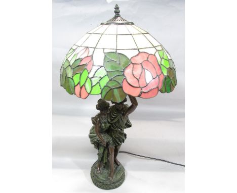 A classical figural table lamp of a young courting couple arm in arm, the boy holding aloft the lamp with a bright floral “le