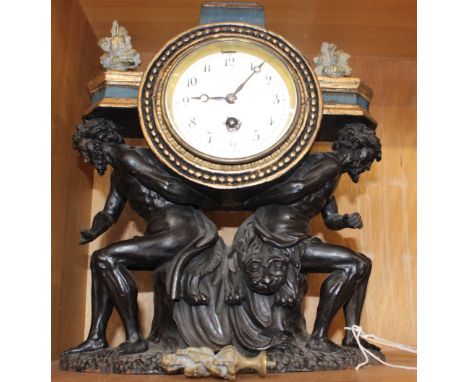 An ebonised and parcel gilt carved wood mantel clock case, probably Italian, mid-19th century, with crouching male figures ea