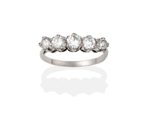 A Diamond Five Stone Ring, the graduated round brilliant cut diamonds in white claw settings to a tapered shoulder plain poli