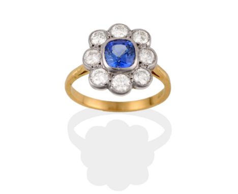 A Sapphire and Diamond Cluster Ring, the cushion cut sapphire within a border of round brilliant cut diamonds in white rubbed