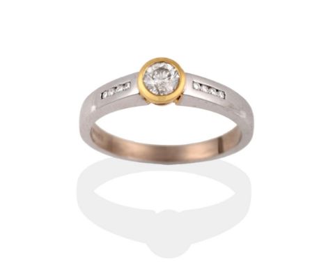 An 18 Carat Gold Diamond Ring, a round brilliant cut diamond in a yellow rubbed over setting, to shoulders inset with round b